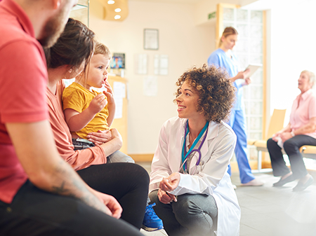 Friendly female clinician talking to an elderly male patient