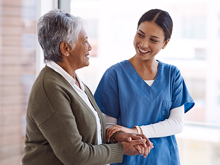 Friendly female clinician smiling at an elderly lady patient